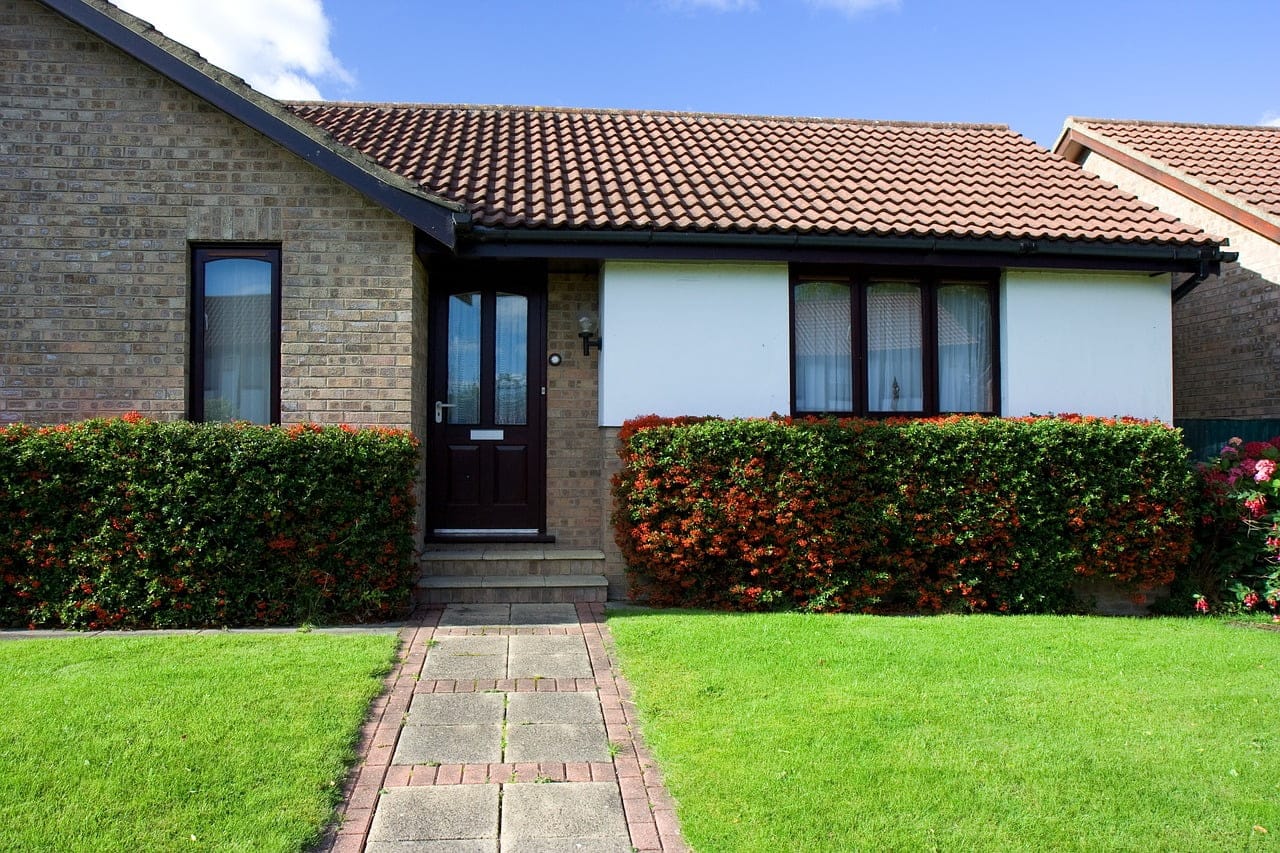 A bungalow with a well-maintained garden and greenery.